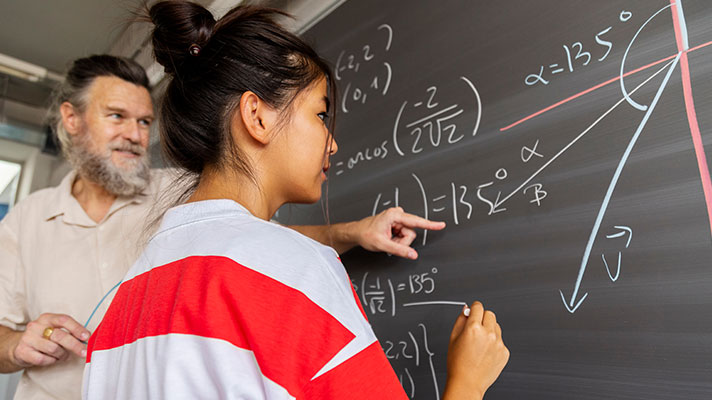 A teacher helps a student with a complex math problem