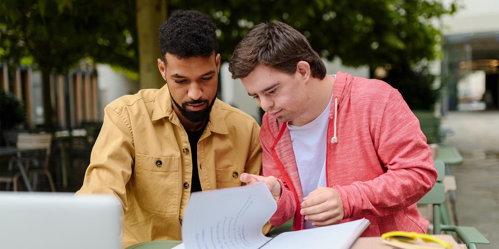 A male teacher works with a special education student on a project