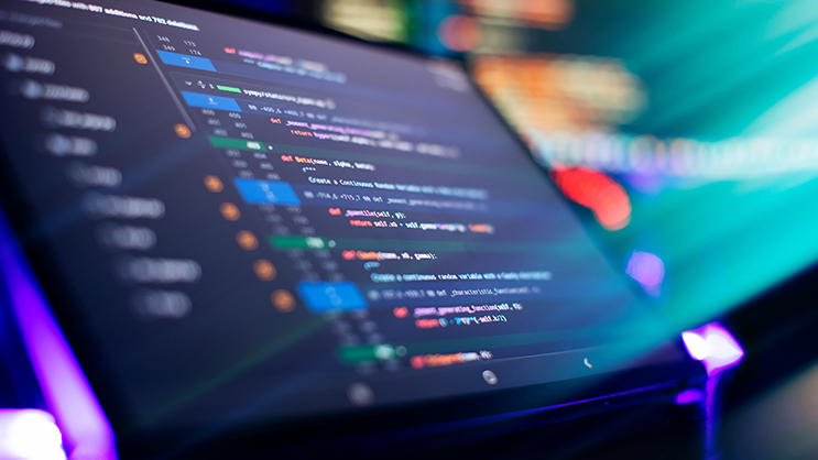 A colorful image of a computer screen. On the screen are lines of software code.