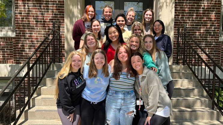 A group of students stand on a set of stairs during an international teaching experience
