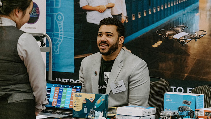 A vendor talks to an attendee at the Indiana STEM Education Conference