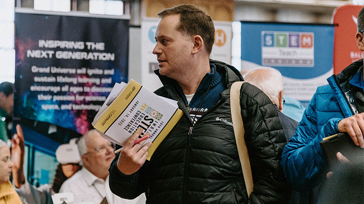 An attendee of the Indiana STEM Education conference looks around the exhibit hall