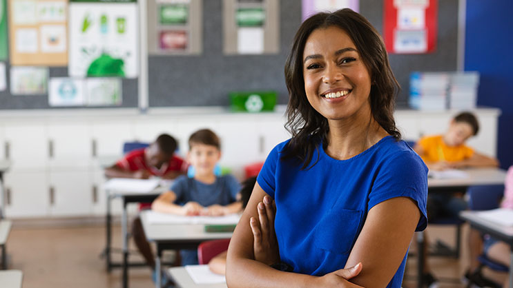 A female teacher stands at the front of a classroom