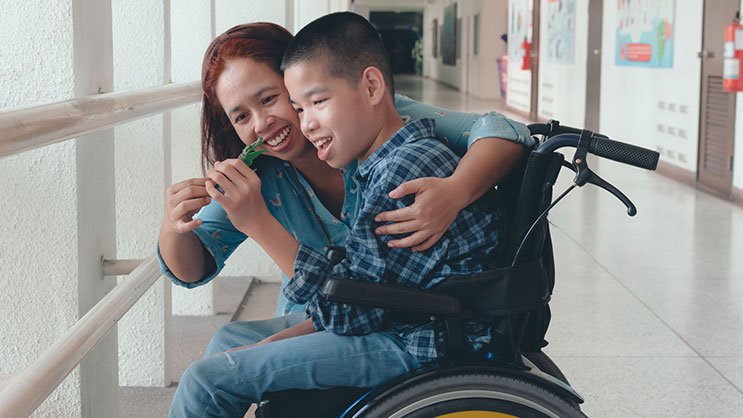 A teacher works with a student in a wheelchair