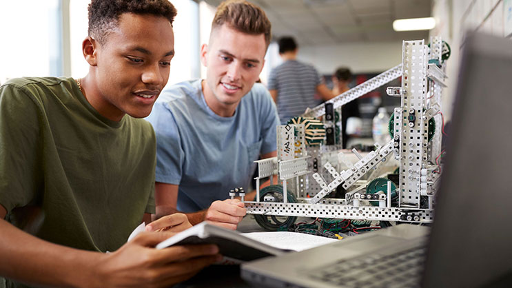 Two male students work on a robotics project