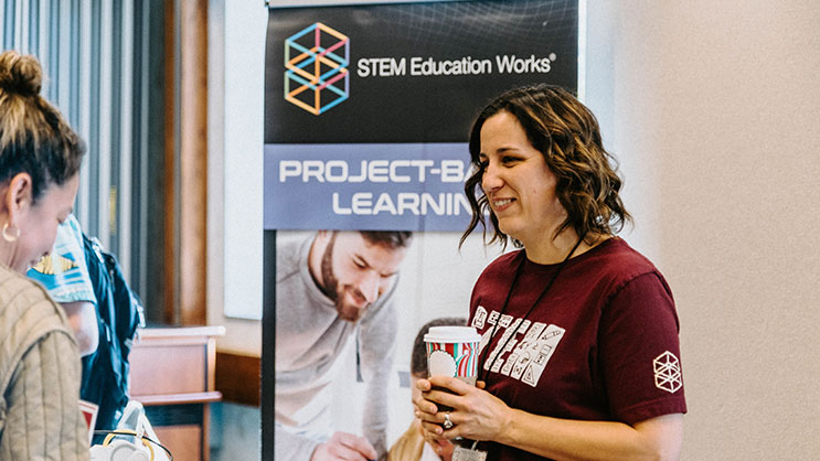 A vendor talks with an attendee at the Purdue AI in Education conference