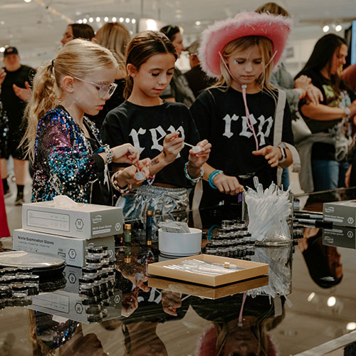 Three young girls work on a mixology experiment before a concert in Indianapolis