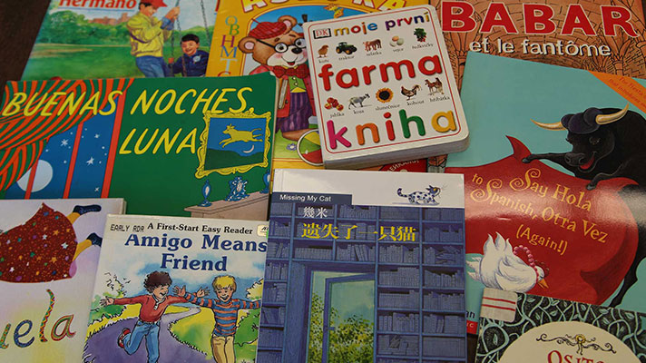 Childrens books in various languages are displayed on a table