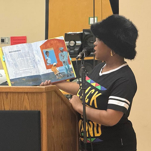 A black student reads aloud from a picture book