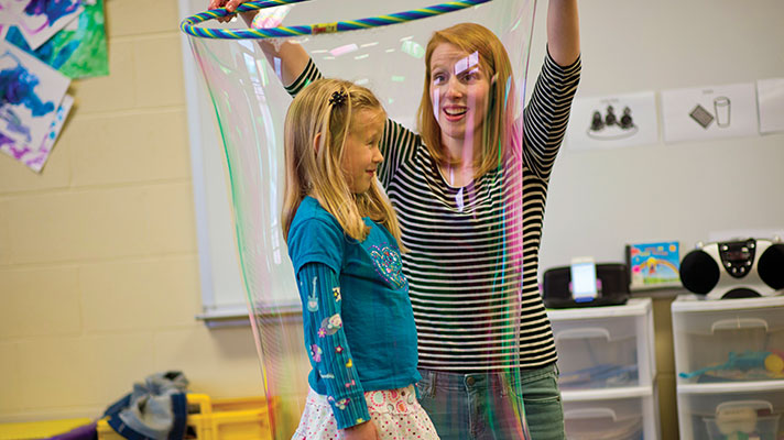 A teacher and a student do an experiment with bubbles