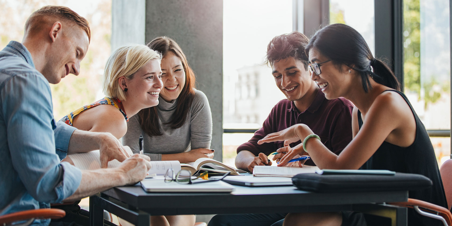A group of people work on a project around a table.