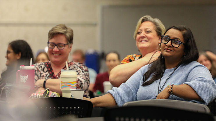 Three attendees listen to a presentation at Purdue University's ICLCLE conference. 