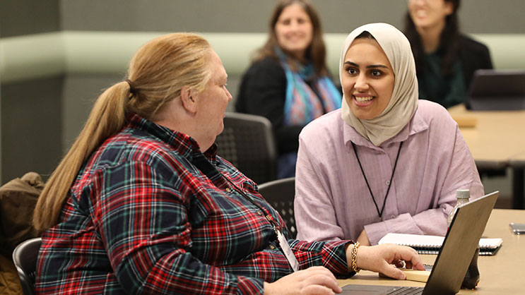Two attendees talk with each other at Purdue University's ICLCLE conference