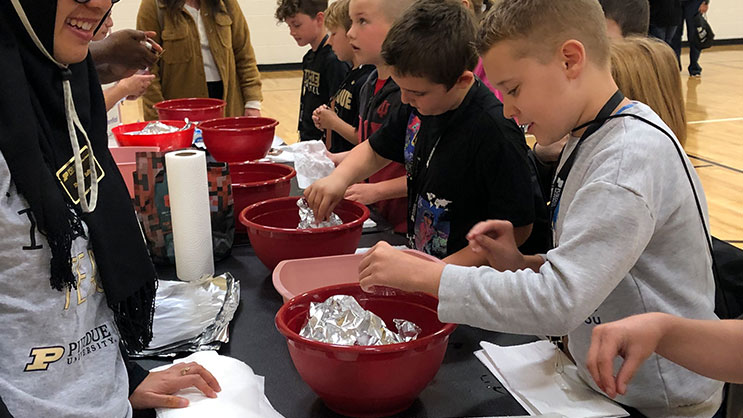 Super Saturday students work on a project using bowls and other materials