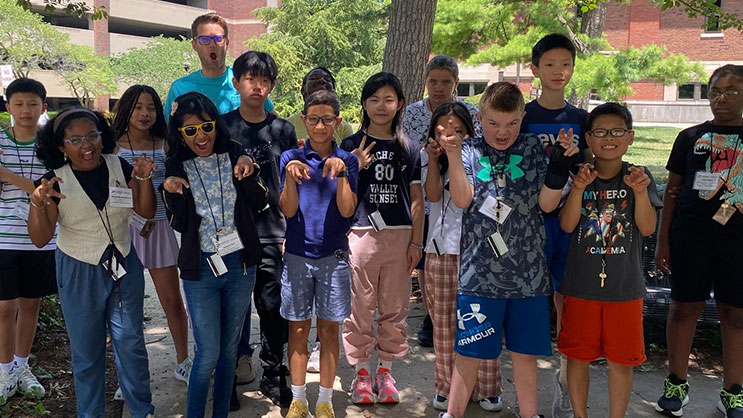 A group of Super Summer campers act like dinosaurs for the camera