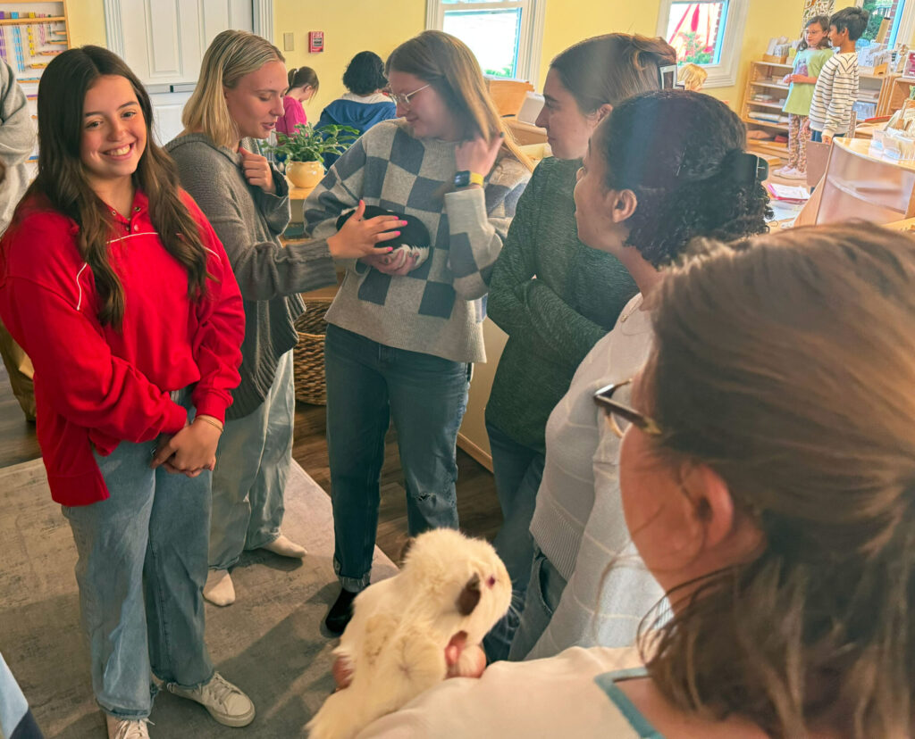 Purdue students standing with a variety of class pets.