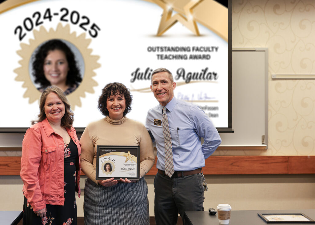 Dr. Juliana Aguilar holding a certificate. Standing with her are Jennifer Smith and Phillip VanFossen.