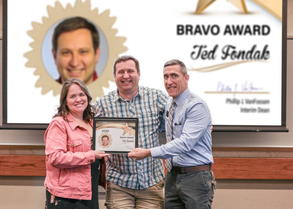 Ted Fondak holding a certificate. Standing with him are Jennifer Smith and Phillip VanFossen.