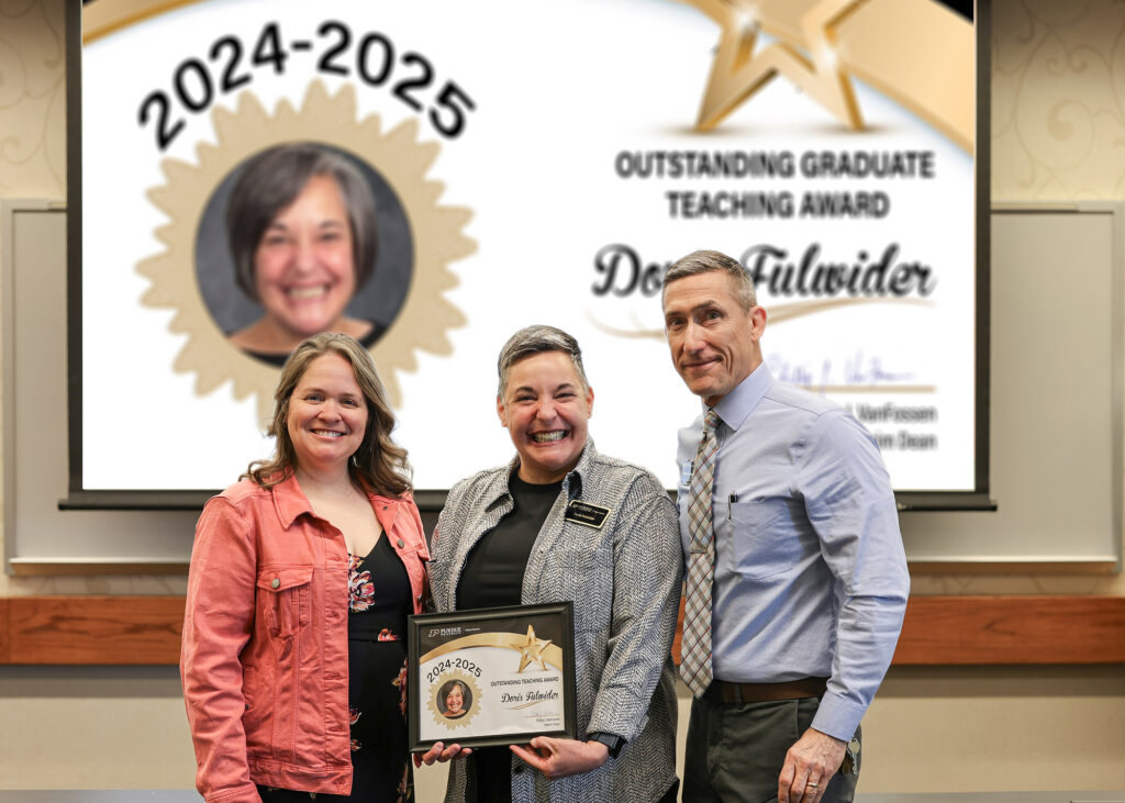 Doris Fulwider holding a certificate. Standing with her are Jennifer Smith and Phillip VanFossen.