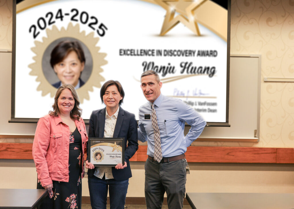 Dr. Wanju Huang holding a certificate. Standing with her are Jennifer Smith and Phillip VanFossen.