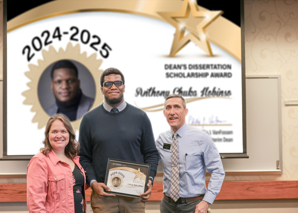 Anthony Ilobinso holding a certificate. Standing with him are Jennifer Smith and Phillip VanFossen.