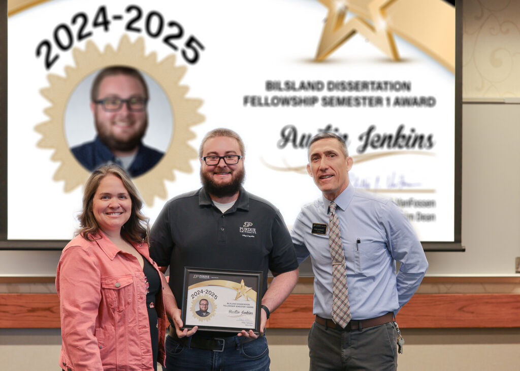 Austin Jenkins holding a certificate. Standing with him are Jennifer Smith and Phillip VanFossen.