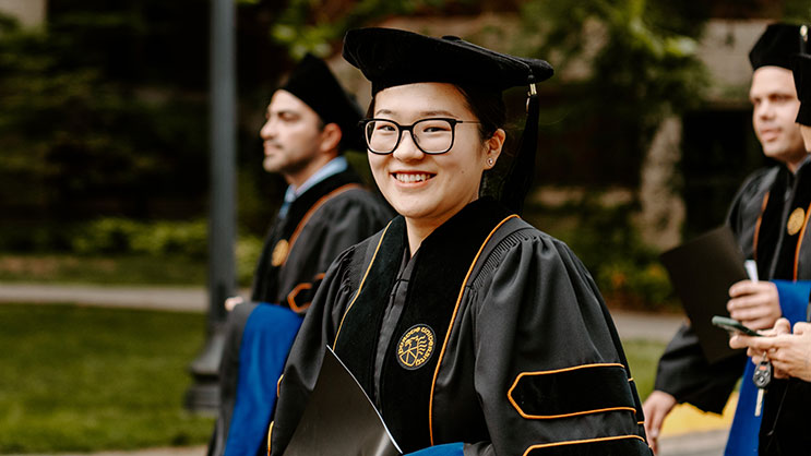 A Purdue University graduate walks in their robes to graduation