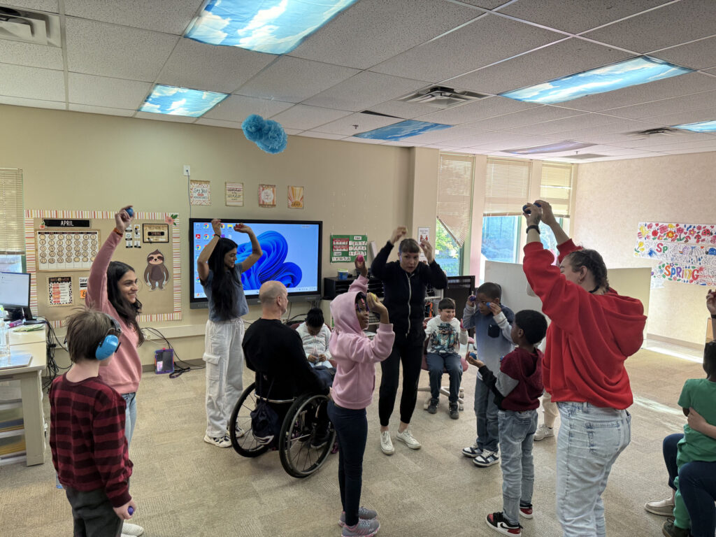 Scheuneman, Laukkanen, and Hernandez demonstrate movement and dance in an autism classroom at Amelia Earhart Elementary School