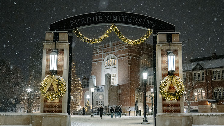 The Purdue Memorial Union on a snowy night with Christmas decorations lit.