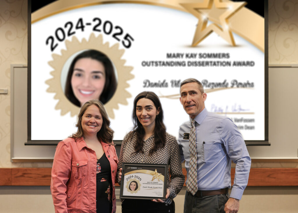 Dr. Daniela Vilarinho Rezende Pereira holding a certificate. Standing with her are Jennifer Smith and Phillip VanFossen.