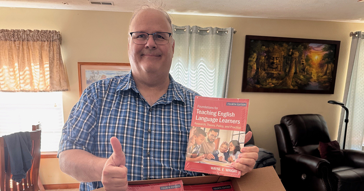 Wayne Wright holding his new book and giving a thumbs up.