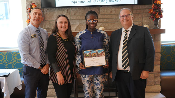 Bukola Abiiba holding a certificate. She is surrounded by Phil VanFossen, Jasmine Begeske, and Wayne Wright.
