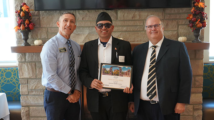 Ghan Shyam Joshi holding a certificate. He is surrounded by Phil VanFossen and Wayne Wright.