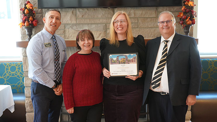 Heather Hayen holding a certificate. She is surrounded by Phil VanFossen, Melanie Kuhn, and Wayne Wright.