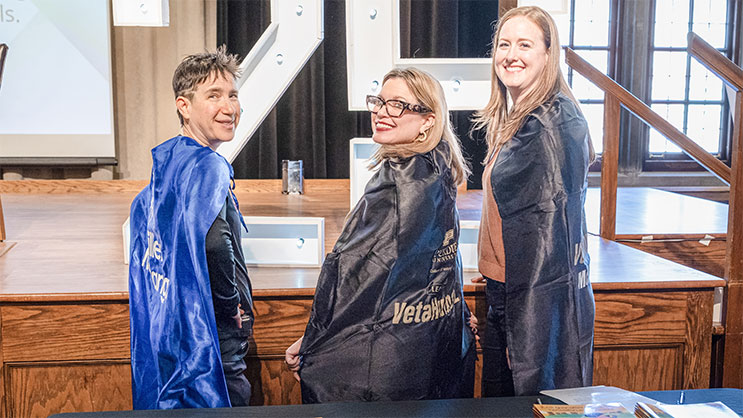 Three women turning around to smile for a photo.