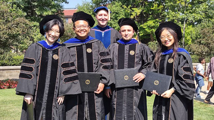 Dr. Eric Deemer poses outside with his 2025 graduates, Chunyu Xu, Denny Putra, Sergio Maldonado Aguinega, and Yujin Song