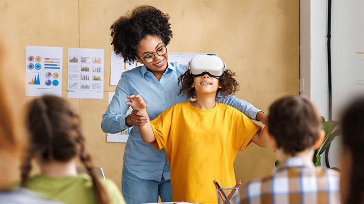 A teacher guiding a student using a virtual reality headset.