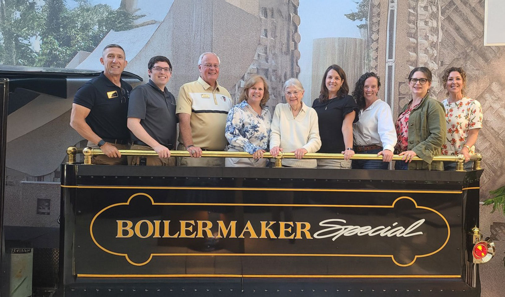 A group of Alumni Engagement Board members standing in the Boilermaker Special train with Phil VanFossen.