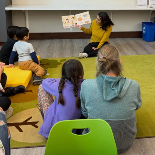 A volunteer reads to a group of students during an El Rincón Bilingüe storytime at the library.