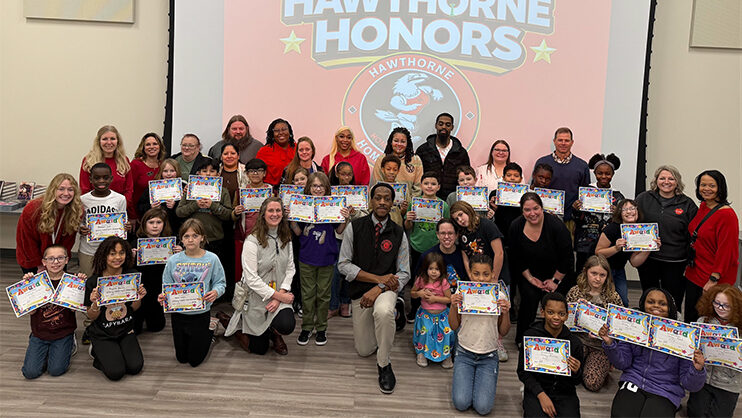 Gregory Butler surrounded by faculty, staff, and students holding certificates.