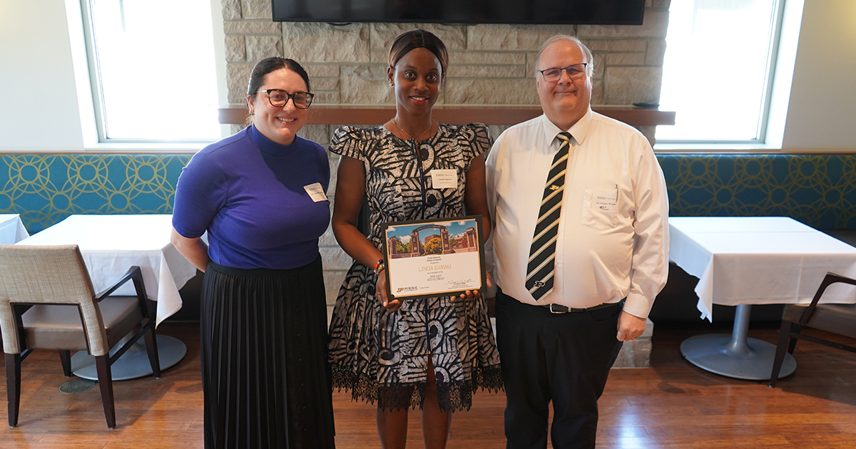 Linda Gwayu holding a certificate. She is surrounded by Danielle Malone and Wayne Wright.