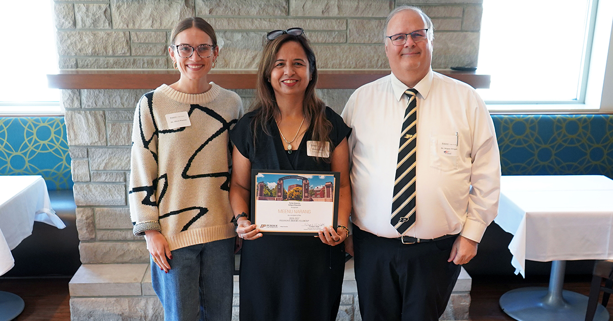 Meenu Narang holding a certificate. She is surrounded by Alison Warren and Wayne Wright.